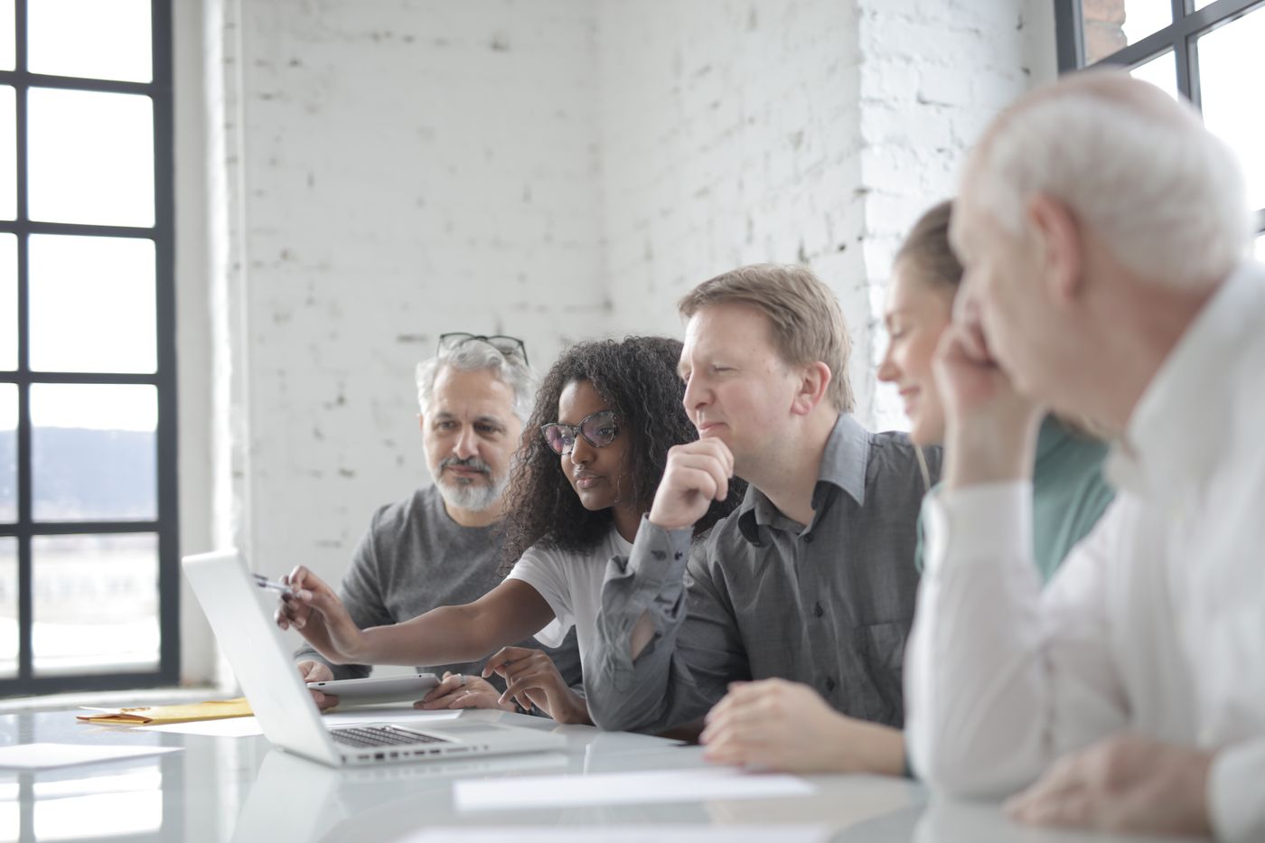 People sitting together at a table looking at a laptop.