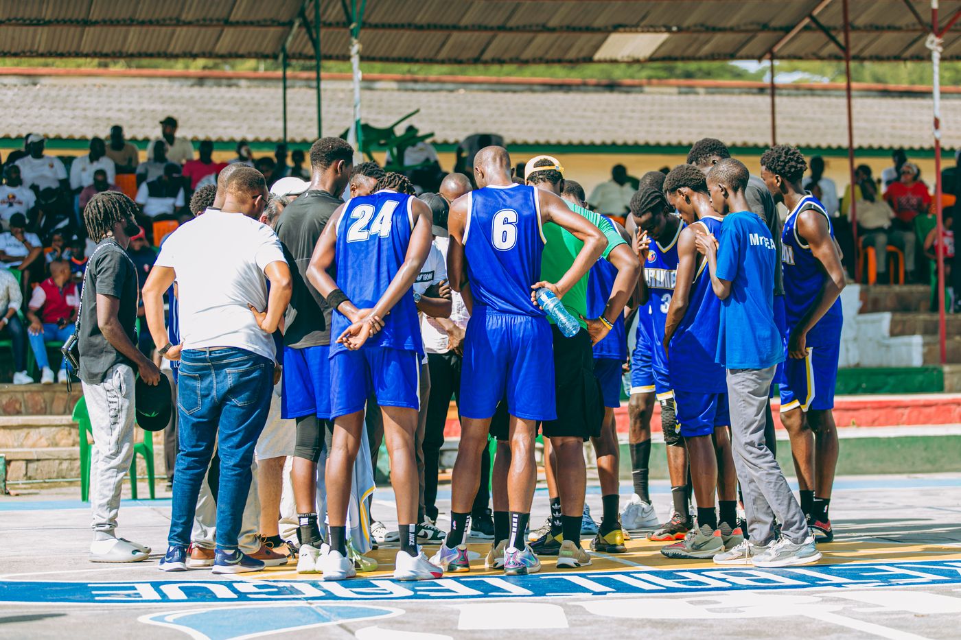 A basketball team huddled with a coach during a game.