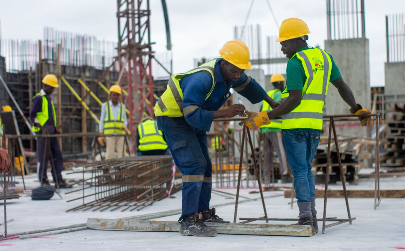 Construction workers on a job site wearing hard hats.