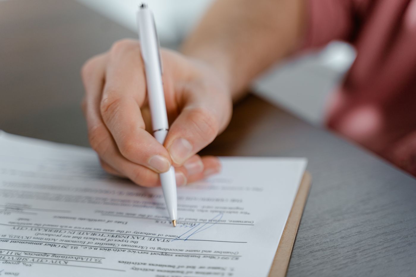 A person signing a paper form.